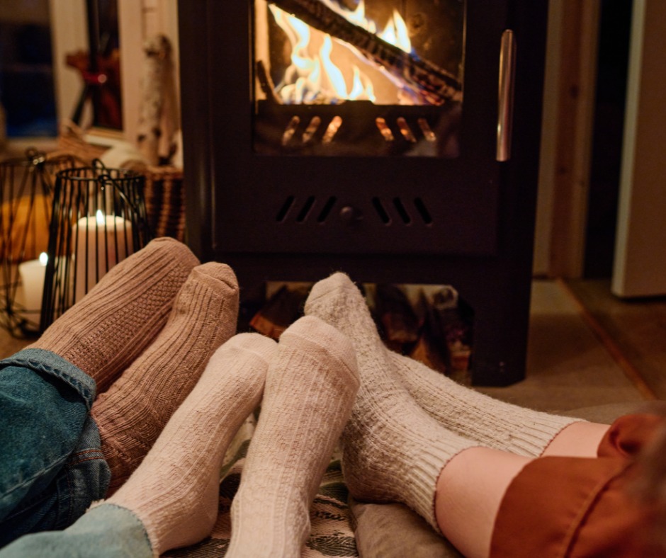 Cosy home comfort - feet in warm socks by a fireplace, showing the warmth and comfort Easy-Sprayaway's insulation services provide